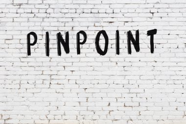 Üzerinde siyah boya bulunan beyaz tuğla bir duvar.