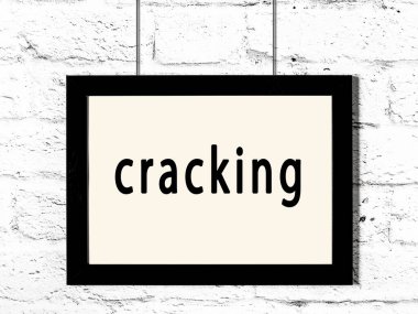 Siyah ahşap çerçeve, beyaz tuğla duvarda yazılar asılı. 