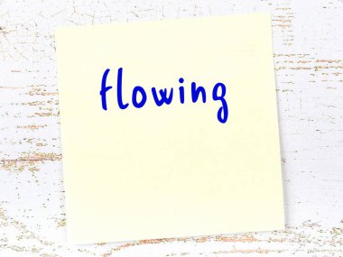 Tahta duvarda sarı yapışkan bir not ve el yazısıyla yazılmış bir yazı var.