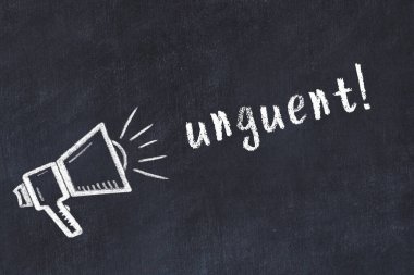 Hoparlörün tebeşir çizimi ve siyah masaya el yazısıyla yazılmış merhem.