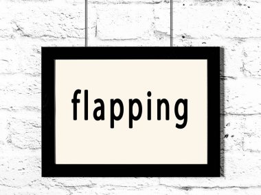 Beyaz tuğla duvarda asılı duran siyah ahşap çerçeve. 