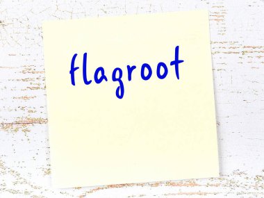 Flagroot 'u hatırlatma kavramı. Tahta duvarda üzerinde yazı olan sarı yapışkan kağıt.