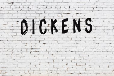 Üzerinde yazı olan beyaz tuğla duvar siyah boyayla yazılmış.