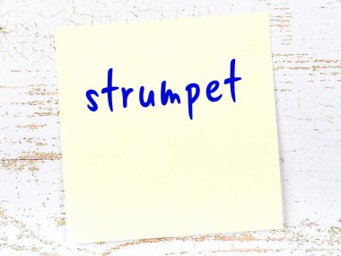 Tahta duvardaki sarı yapışkan notta el yazısıyla yazılmış fahişe yazıyor.