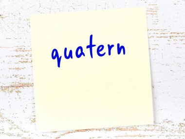 Tahta duvarda el yazısıyla yazılmış sarı yapışkan bir not var.