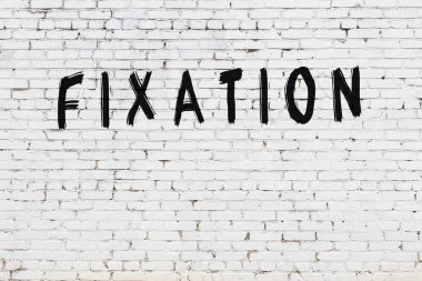 Üzerinde siyah boya bulunan beyaz tuğla bir duvar.