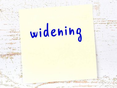 Genişleme konusunda hatırlatma kavramı. Tahta duvarda üzerinde yazı olan sarı yapışkan kağıt.