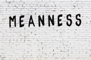 Beyaz tuğladan duvar, siyah boyayla yazılmış.