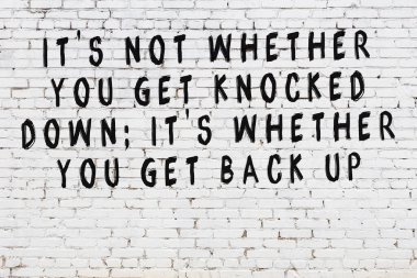 Üzerinde mantıklı alıntıların yazılı olduğu siyah boyanmış beyaz tuğla duvar.