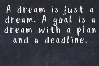 Siyah masa üzerine tebeşirle yazılmış zekice bir söz.