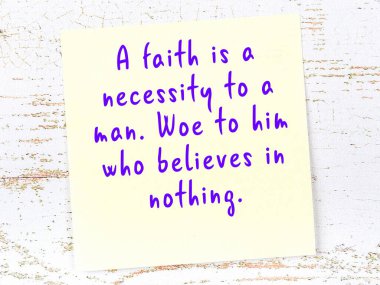 Sarı yapışkan not, ahşap duvarda el yazısıyla yazılmış zekice bir alıntıyla.