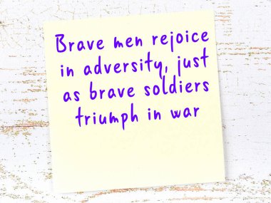 Tahta duvarda el yazısı motivasyon alıntısı olan sarı yapışkan not