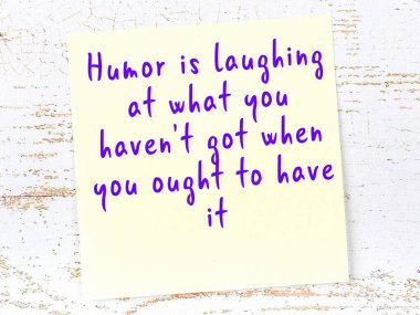 Sarı yapışkan not, ahşap duvarda el yazısıyla yazılmış zekice bir alıntıyla.