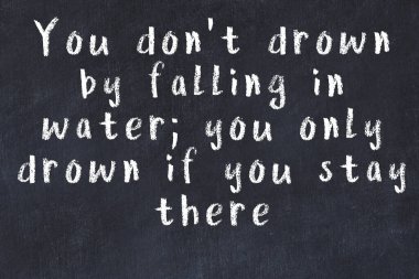 Siyah masa üzerine tebeşirle yazılmış zekice bir söz.