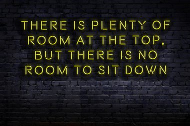 Tuğla duvardaki bilgece alıntıların neon yazıları üzerine gece görüşü