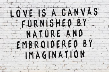 Beyaz tuğla duvar ve bilgece alıntıların yazılı olduğu siyah yazı.