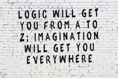 Üzerinde mantıklı alıntıların yazılı olduğu siyah boyanmış beyaz tuğla duvar.