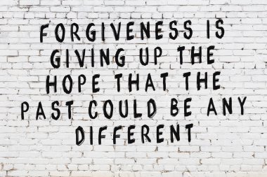 Beyaz tuğla duvara zekice alıntılar yazılı siyah bir yazı.