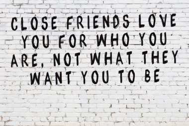 Beyaz tuğla duvar ve bilgece alıntıların yazılı olduğu siyah yazı.