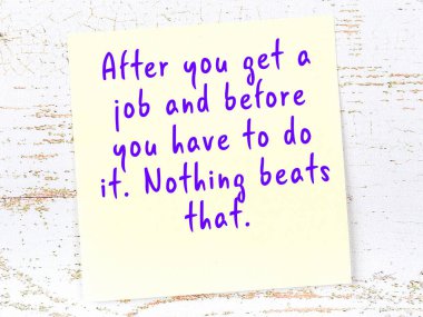 Tahta duvarda el yazısı motivasyon alıntısı olan sarı yapışkan not