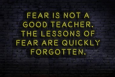 Tuğla duvardaki ışıklı neon tabela olarak bilgece alıntı