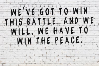 Üzerinde mantıklı alıntıların yazılı olduğu siyah boyanmış beyaz tuğla duvar.