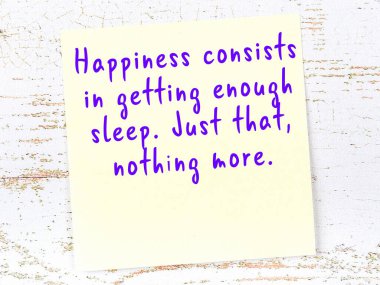 Tahta duvarda asılı sarı yapışkan nota elle yazılmış bilgece bir alıntı.