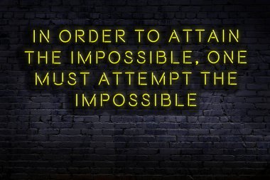 Tuğla duvardaki bilgece alıntıların neon yazıları üzerine gece görüşü