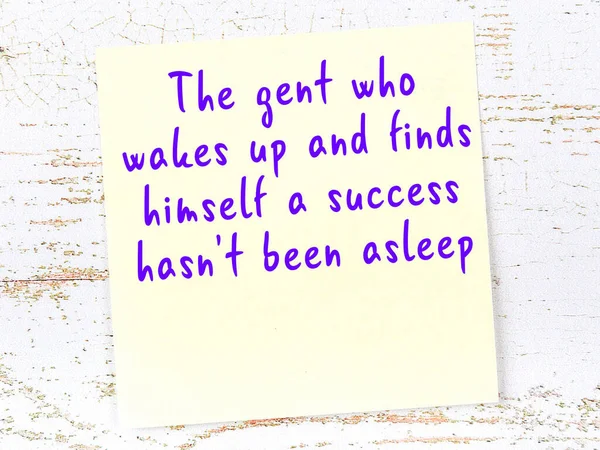 Sarı yapışkan not, ahşap duvarda el yazısıyla yazılmış zekice bir alıntıyla.