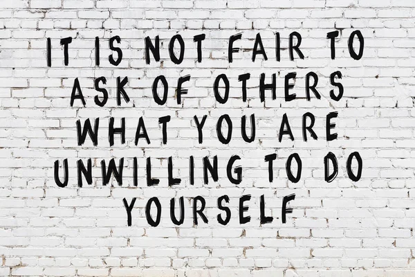 Üzerinde mantıklı alıntıların yazılı olduğu siyah boyanmış beyaz tuğla duvar.