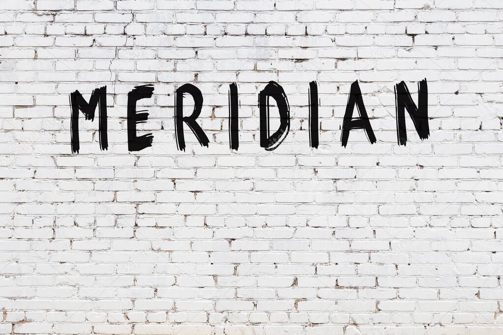 White brick wall with inscription meridian handwritten with black paint