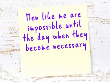 Tahta duvarda el yazısı motivasyon alıntısı olan sarı yapışkan not