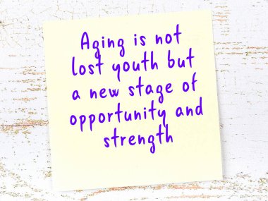 Sarı yapışkan not, ahşap duvarda el yazısıyla yazılmış zekice bir alıntıyla.