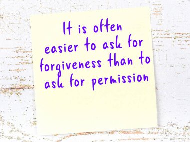 Sarı yapışkan not, ahşap duvarda el yazısıyla yazılmış zekice bir alıntıyla.