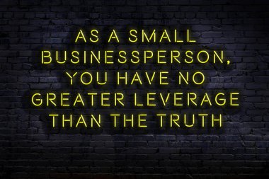 Tuğla duvardaki ışıklı neon tabela olarak bilgece alıntı