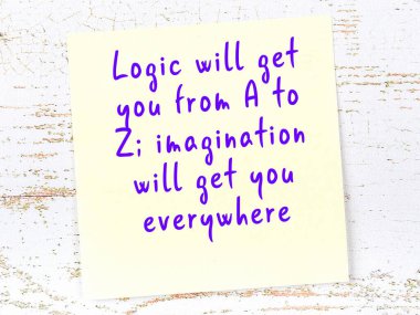 Sarı yapışkan not, ahşap duvarda el yazısıyla yazılmış zekice bir alıntıyla.