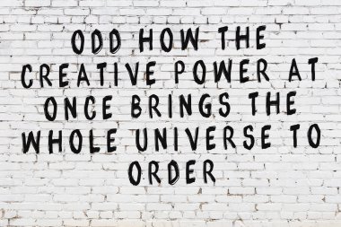 Beyaz tuğla duvar ve bilgece alıntıların yazılı olduğu siyah yazı.