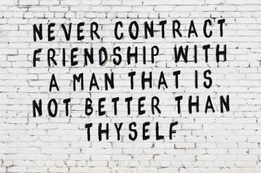 Üzerinde mantıklı alıntıların yazılı olduğu siyah boyanmış beyaz tuğla duvar.