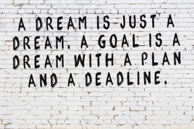 Üzerinde mantıklı alıntıların yazılı olduğu siyah boyanmış beyaz tuğla duvar.