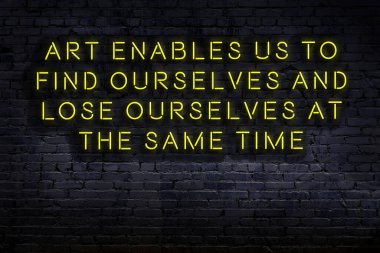 Tuğla duvardaki bilgece alıntıların neon yazıları üzerine gece görüşü