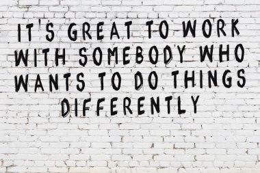 Üzerinde mantıklı alıntıların yazılı olduğu siyah boyanmış beyaz tuğla duvar.