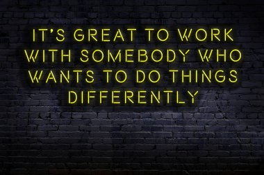 Tuğla duvardaki bilgece alıntıların neon yazıları üzerine gece görüşü