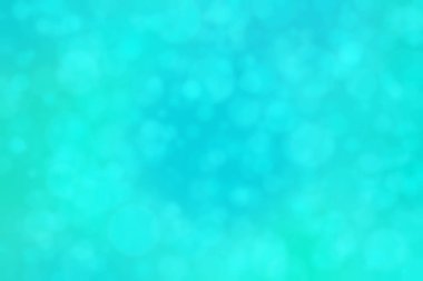 Çember şeklindeki bokeh noktalarıyla mavi ve yeşil soyut odaklanmış arkaplan