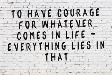 Beyaz tuğla duvar ve bilgece alıntıların yazılı olduğu siyah yazı.