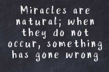 Siyah masa üzerine tebeşirle yazılmış zekice bir söz.