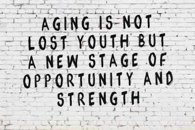 Beyaz tuğla duvar ve bilgece alıntıların yazılı olduğu siyah yazı.