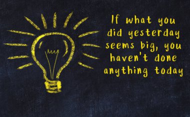 Bilgece bir alıntı ve siyah karatahtaya bir ampul çizimi