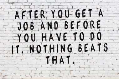 Beyaz tuğla duvar ve bilgece alıntıların yazılı olduğu siyah yazı.