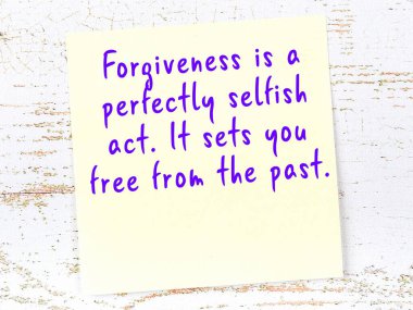 Tahta duvarda el yazısı motivasyon alıntısı olan sarı yapışkan not