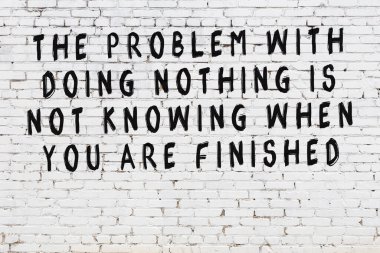 Beyaz tuğla duvar ve bilgece alıntıların yazılı olduğu siyah yazı.